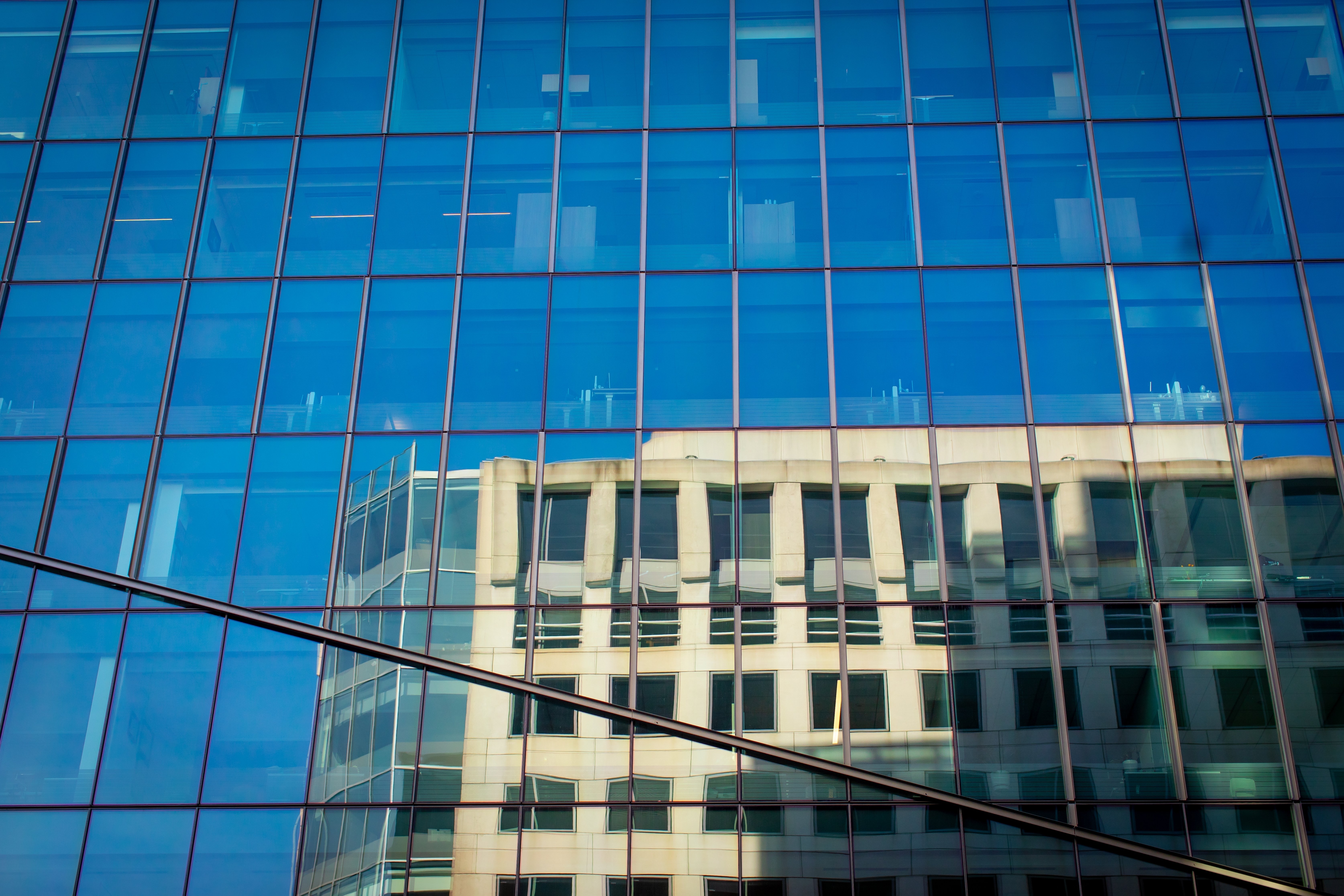 stock-photo-bottom-up-view-of-the-glass-facade-of-a-modern-building-geometry-in-architecture-tilt-bottom-2573318903